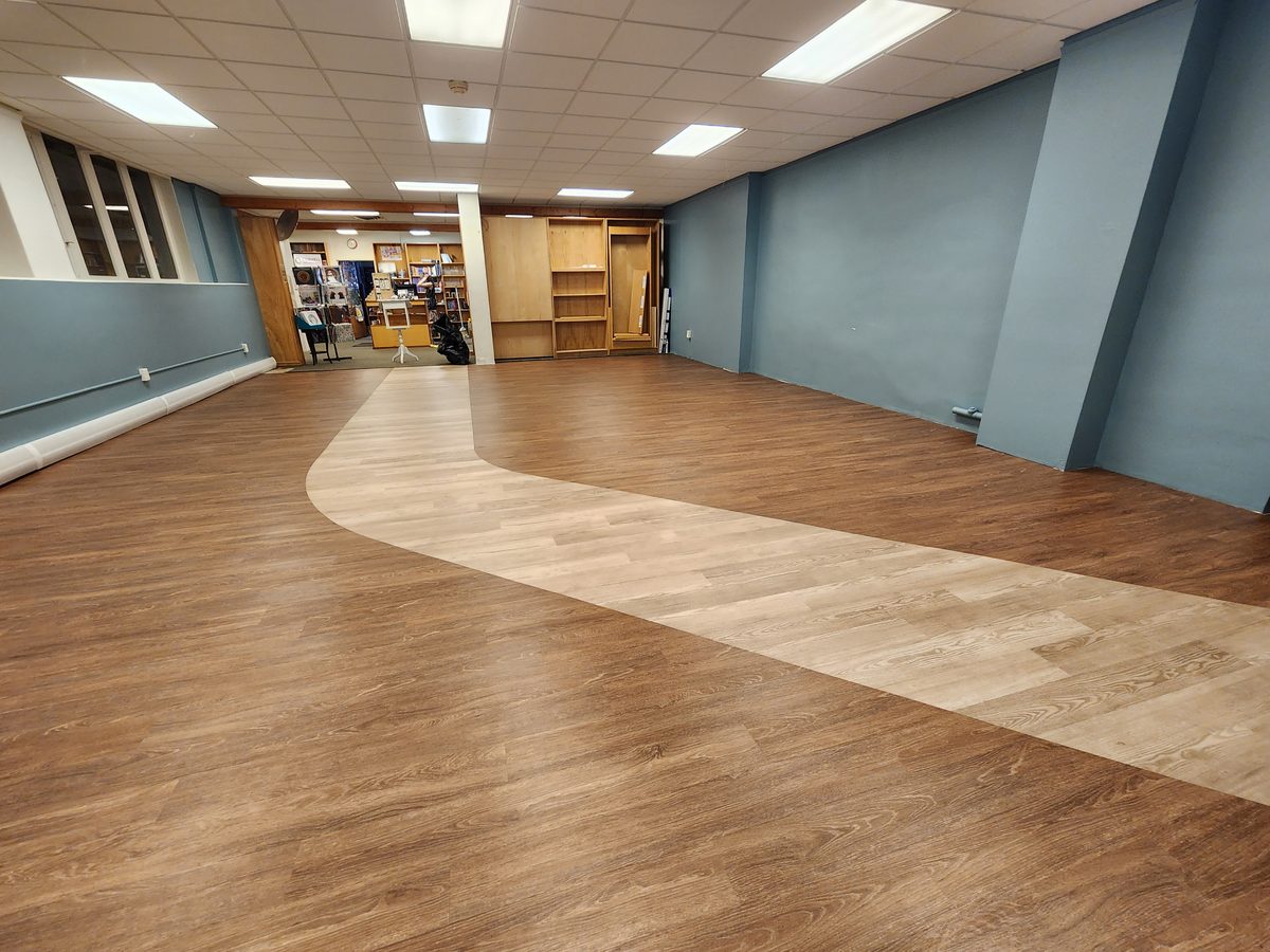 Finished commercial floor in Ithaca with a curved inlay sweeping through the room