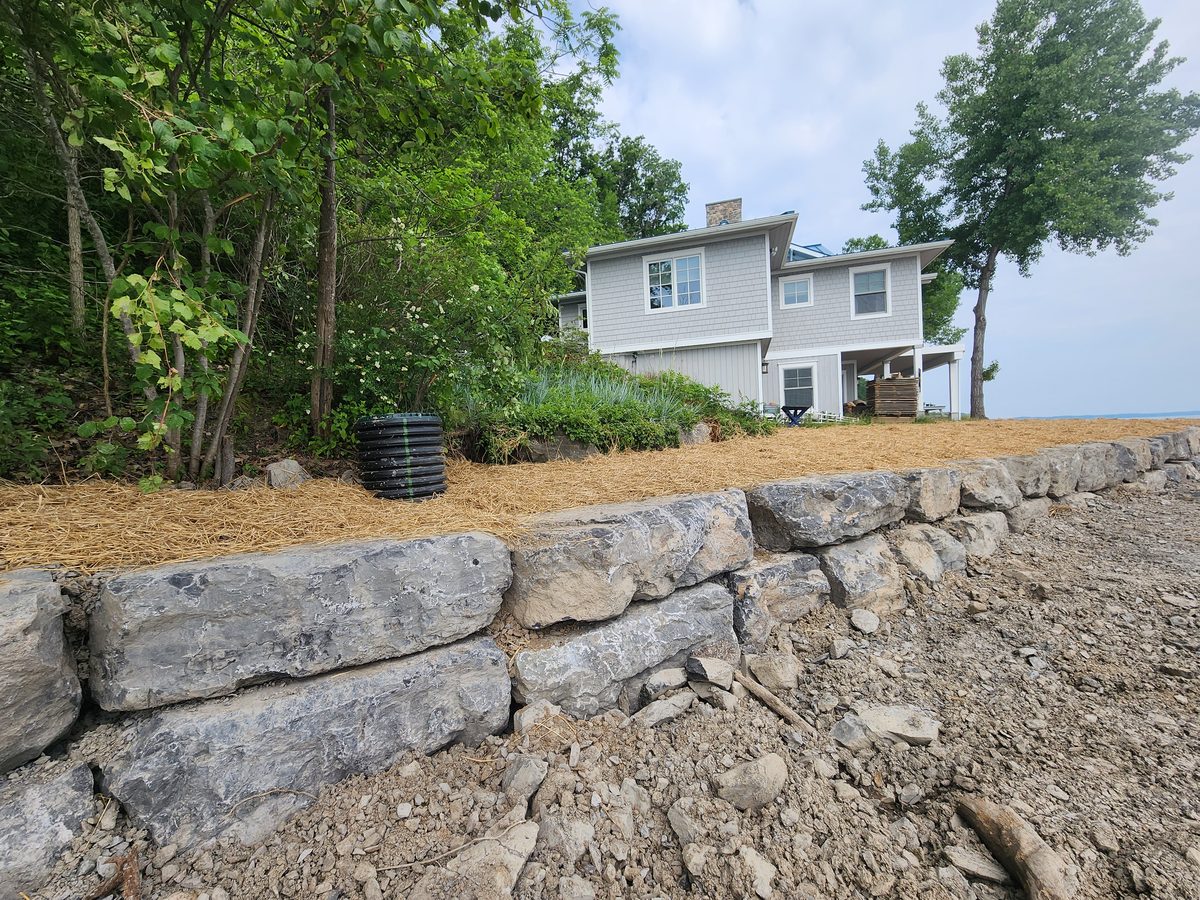 Armour stone wall with the house behind