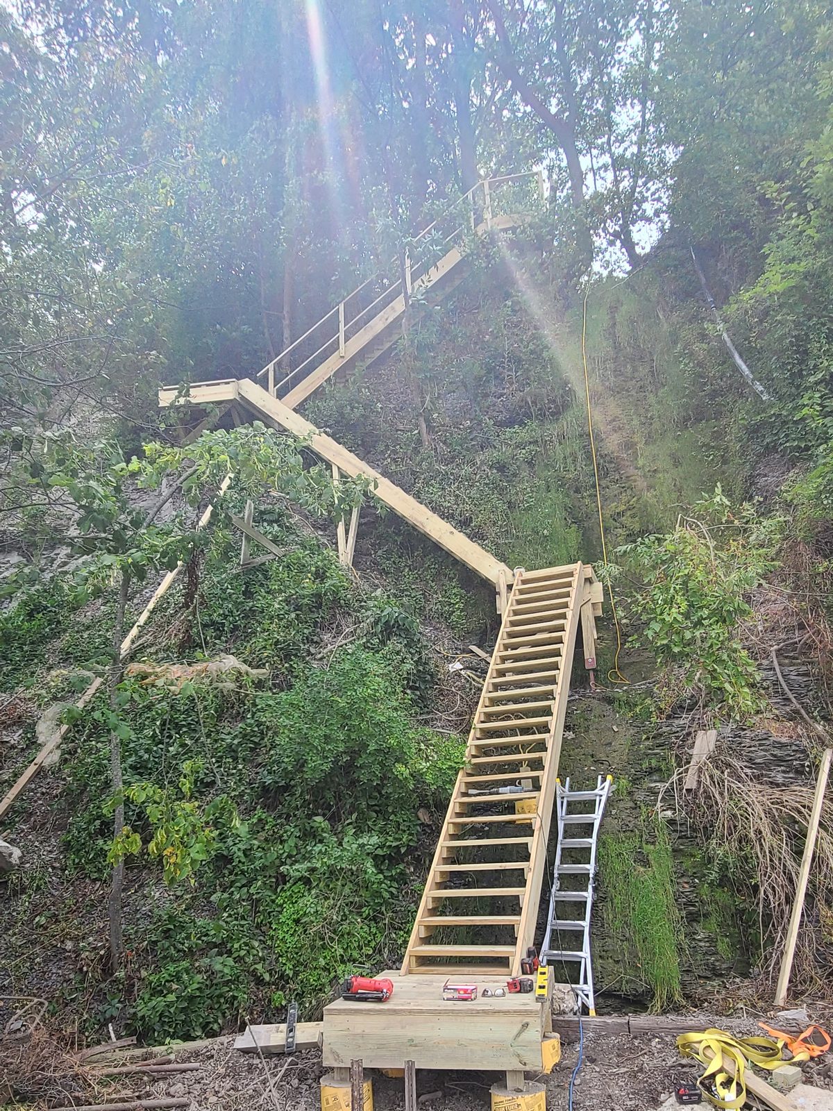 Stair stringers and landings framed against the ravine wall