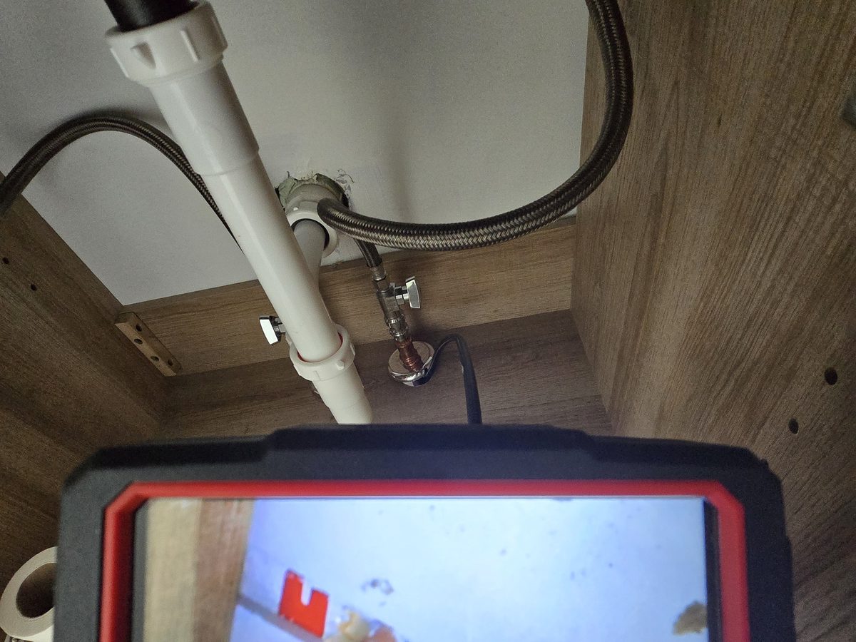 Pipe inspection camera run under a vanity