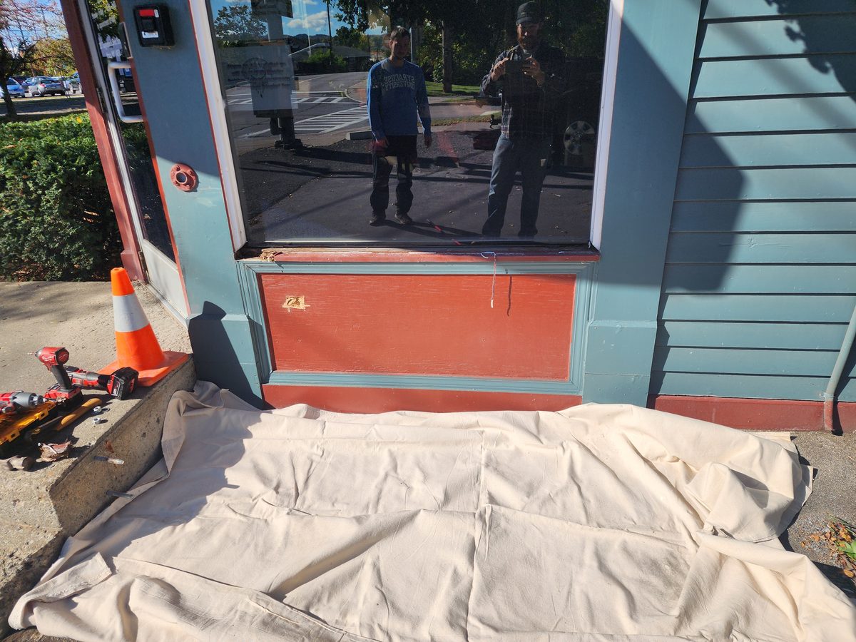 Commercial storefront window repair with the work area covered