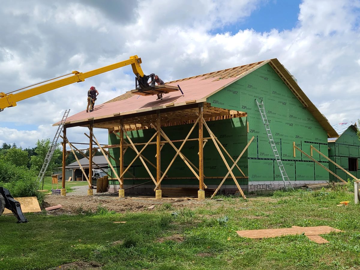 Outbuilding wrapped in weather barrier with the roof deck going on
